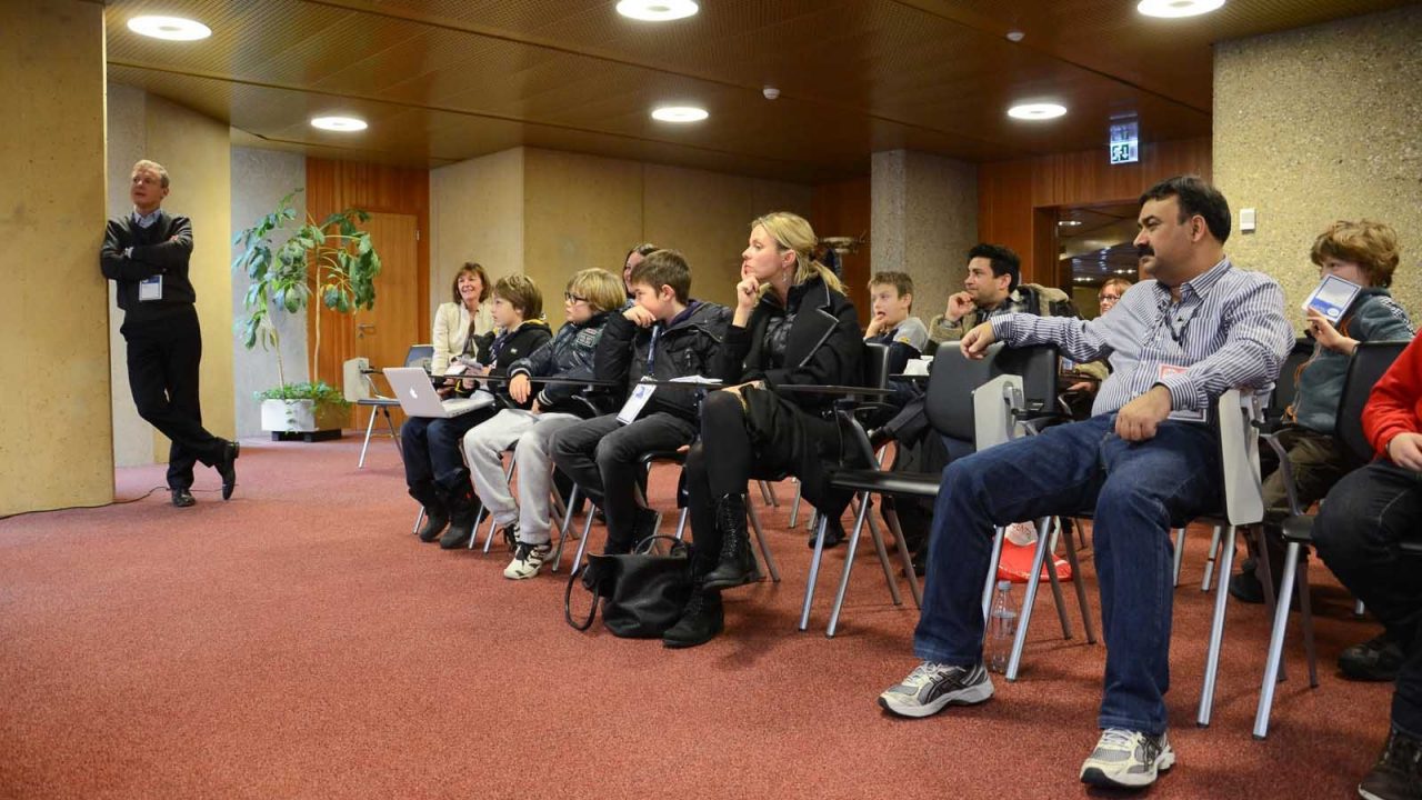 Children gathered around laptops playing Minecraft at a workshop